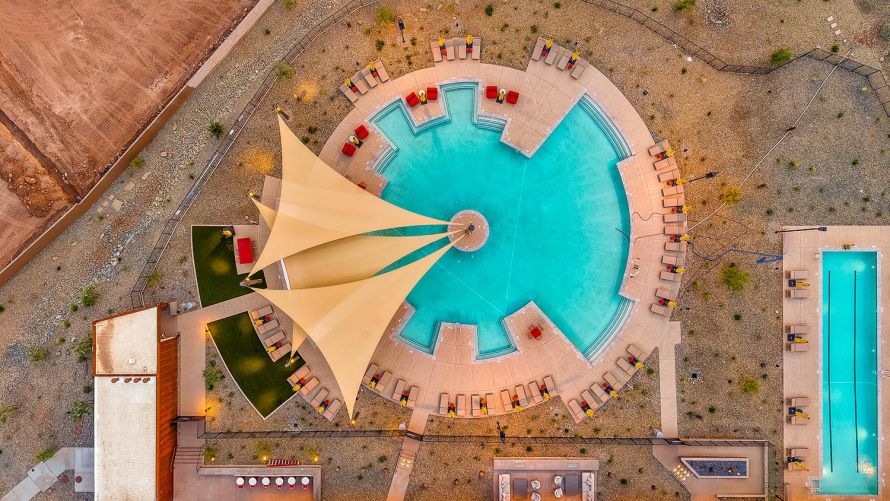 Aerial bird's-eye view of a circular swimming pool surrounded by lounge chairs