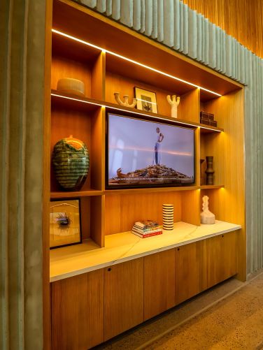 Wooden built-in shelving unit with a television and minimalist decorative vases