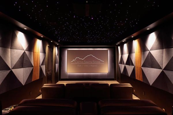 Modern home theater room with leather seating, geometric wall panels, and a star-lit ceiling