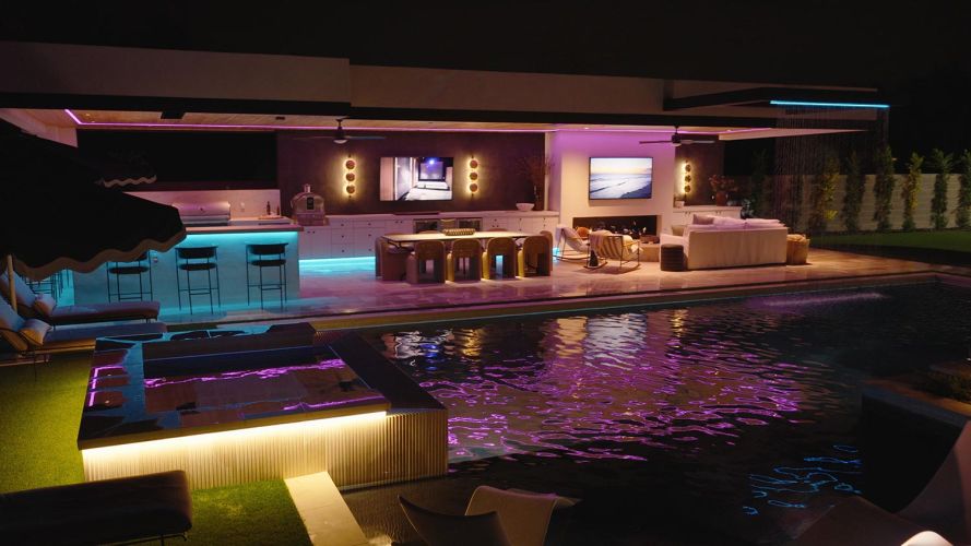 Night view of an illuminated swimming pool and outdoor living space